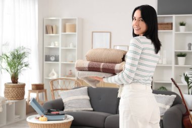 Evinde bir yığın sıcak ekoseli güzel, mutlu bir kadın.