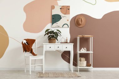 Odanın içi boyalı, raf ünitesi ve bitki dolu.