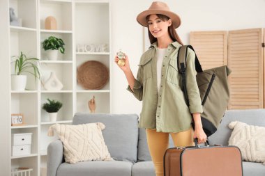 Evde pusula ve çantaları olan kadın turist.