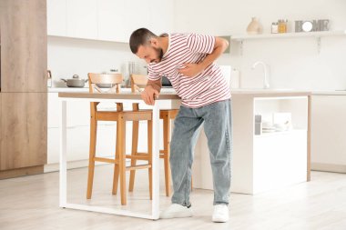 Evdeki masada kalp krizi geçiren genç bir adam.