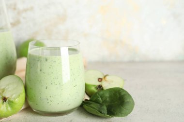 Beyaz arkaplanlı bir bardak taze ıspanaklı smoothie.