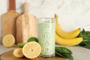 Beyaz arka planda limonlu ve muzlu taze ıspanaklı smoothie.