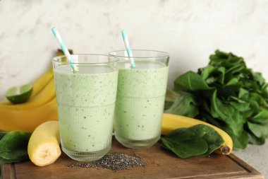 Beyaz arka planda muzlu ve chia tohumlu taze ıspanaklı smoothie.