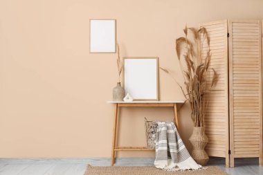 Boş çerçeveleri, masa ve otları olan bir oda.