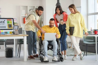 Tasarımcılar takımı ve tekerlekli sandalyedeki adam.