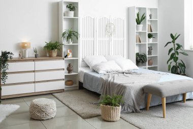 Konforlu yatak, raf üniteleri ve yatak odasının içindeki çekmeceler.