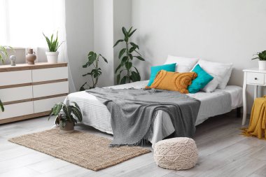 Ev bitkileriyle dolu modern şık bir yatak odası.