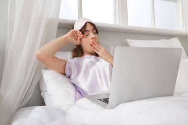 Evde dizüstü bilgisayarla uyuduktan sonra güzel bir genç kadın.