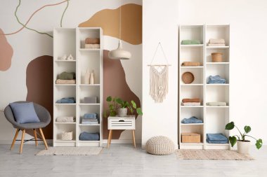 Giysileri ve çiçekleri olan modern soyunma odasının şık bir iç mekanı.