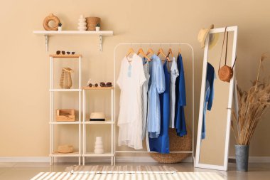 Farklı şık kıyafetlerle ve oturma odasında aksesuarlı raflarla doldur.