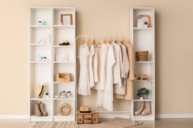 Farklı şık kıyafetlerle rafları ve ayakkabıları ve aksesuarları oturma odasına koyun.