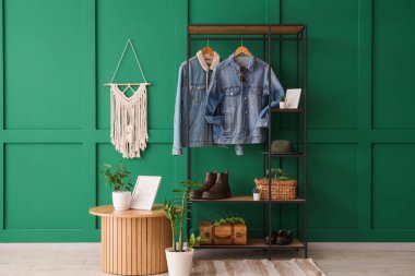 Askısı, kot ceketi ve masası olan bir oda.