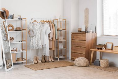 Giysi askısı, raf ünitesi ve çekmeceleri olan soyunma odasının içinde.