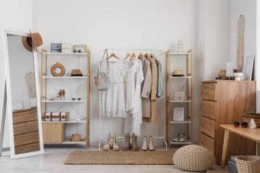 Giysi askısı, raf ünitesi ve çekmeceleri olan soyunma odasının içinde.