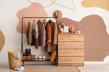 Erkek kıyafetleri ve çekmeceleri olan bir oda.