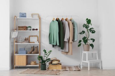 Giysi askısı ve raf ünitesi olan soyunma odasının içinde.