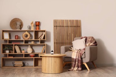 Gri koltuğu, sehpası ve kitaplığı olan şık bir oturma odası.