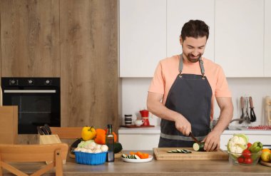 Mutfakta kabak kesen yakışıklı sakallı adam.