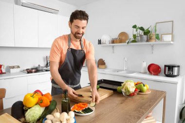 Mutfakta kabak kesen yakışıklı sakallı adam.