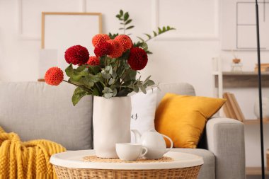 Çok güzel çiçekli vazo ve oturma odasındaki sehpanın üzerinde çay.