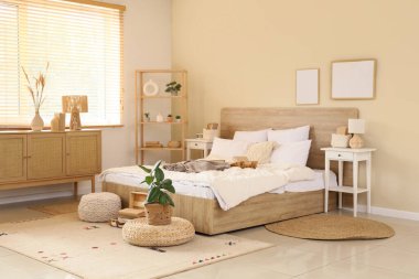 Şık bir yatak odası, rahat bir yatak odası, çiçekleri ve kitapları var.