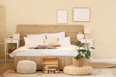 Şık bir yatak odası, rahat bir yatak odası, çiçekleri ve kitapları var.