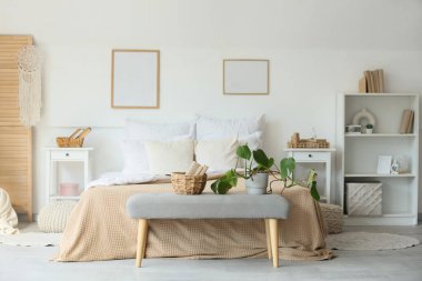 Yatak odasının içinde rahat bir yatak odası ve yatağın yanında kitaplar var.