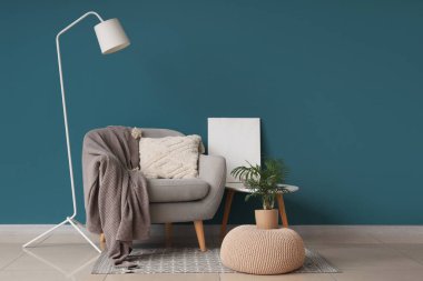 Gri koltuklu, rahat battaniyeli ve kahve masalı şık bir oturma odası.