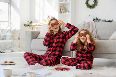 Kurabiyeli şirin kız kardeşler kış günü evde oturuyor.