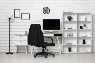 Çalışma yeri ve raf ünitesi olan modern ofis.