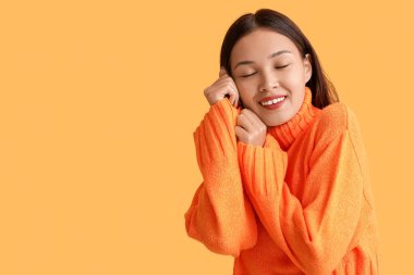 Turuncu örgü süveter giyen güzel bir kadın.