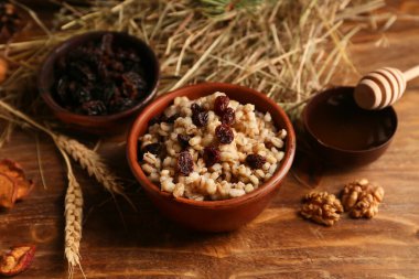 Tahta zemin üzerinde buğday ve bal bulunan geleneksel Ukrayna Kutya tabağı