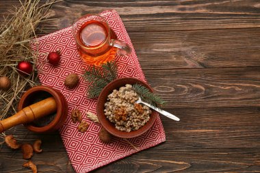 Bir kase geleneksel Ukrayna Kutya yemeği, köknar dalları ve tahta arka planda bir sürahi Uzvar.