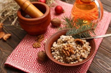 Bir kase geleneksel Ukrayna Kutya yemeği, köknar dalları ve tahta arka planda bir sürahi Uzvar.