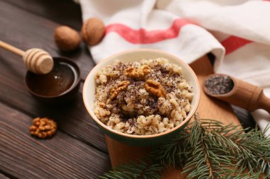 Ahşap zemin üzerinde bal ve Noel ağacı dalı olan geleneksel Ukrayna Kutya tabağı