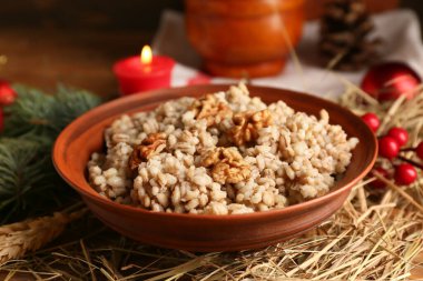 Noel ağacı dallı geleneksel Ukrayna Kutya çanağı ve ahşap arka planda yanan mum, yakın plan