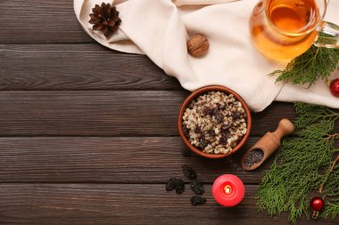 Bir kase geleneksel Ukrayna Kutya yemeği, kozalaklı dallar ve tahta arka planda bir sürahi Uzvar.