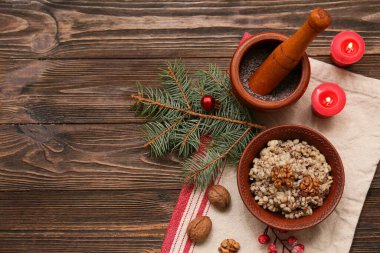 Noel ağacı dallı geleneksel Ukrayna Kutya tabağı ve ahşap zemin üzerinde yanan mumlar.