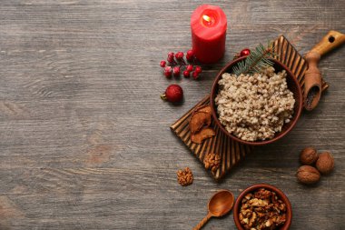 Bir kase geleneksel Ukrayna Kutya yemeği Noel topları ve ahşap arka planda yanan mum.