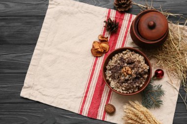 Çam kozalaklı geleneksel Ukrayna Kutya tabağı ve siyah ahşap arka planda Noel ağacı dalı