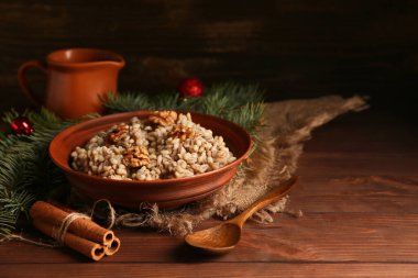 Tarçınlı geleneksel Ukrayna Kutya yemeği ve ahşap arka planda Noel ağacı dalları