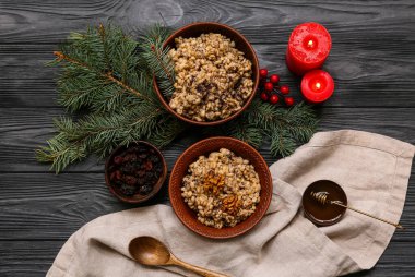 Geleneksel Ukrayna Kutya tabakları Noel ağacı dalları ve siyah ahşap arka planda yanan mumlar.