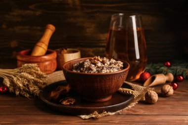 Tahta zemin üzerinde buğday ve Noel topları bulunan geleneksel Ukrayna Kutya tabağı