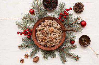 Köknar dalları ve beyaz ahşap arka planda Noel topları olan geleneksel Ukrayna Kutya tabağı