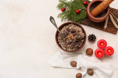 Bir kase geleneksel Ukrayna Kutya yemeği kozalaklı ve beyaz arka planda yanan mumlar.