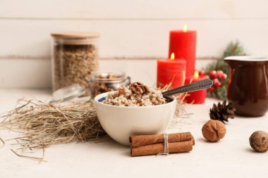 Tarçınlı geleneksel Ukrayna Kutya yemeği ve beyaz masada yanan mumlar.