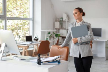 Ofisinde dosyası olan genç bir iş kadını.