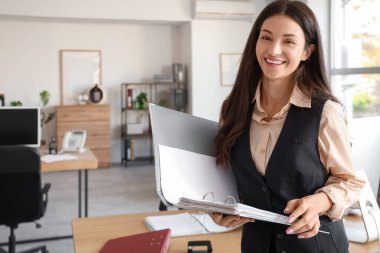 Ofisinde dosyası açık güzel bir iş kadını.