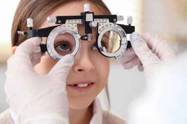 Kadın göz doktoru, klinikte küçük bir kızı yargılıyor, yakın plan.