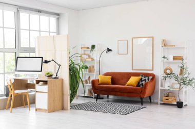 Kahverengi kanepesi, katlanır perdesi ve rahat çalışma yeri olan şık bir oturma odası.